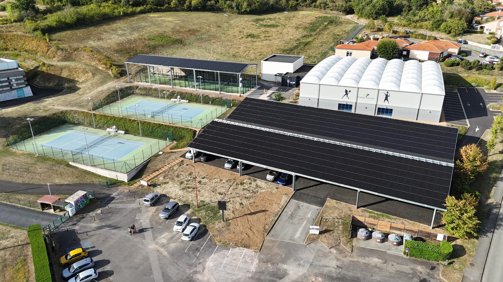 Vue drone du parking couvert d'ombrières solaires et des terrains de padel