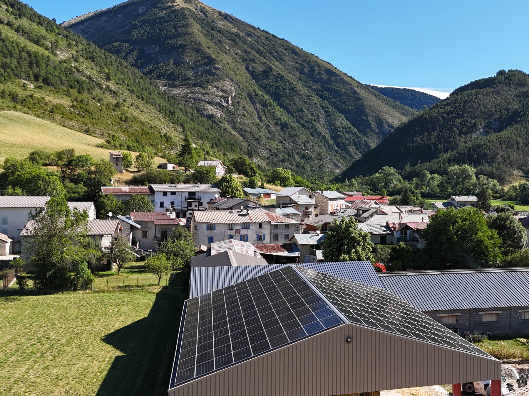 Photovoltaic roof of a farm building, at the foot of the mountains