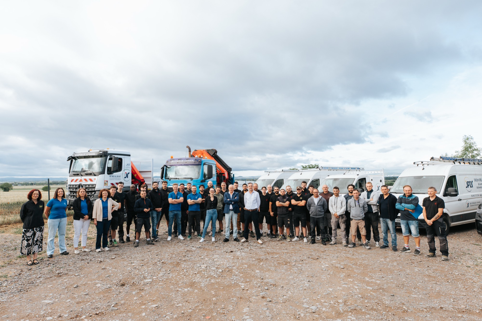 All JR Groupe employees lined up in front of the company's trucks and vans